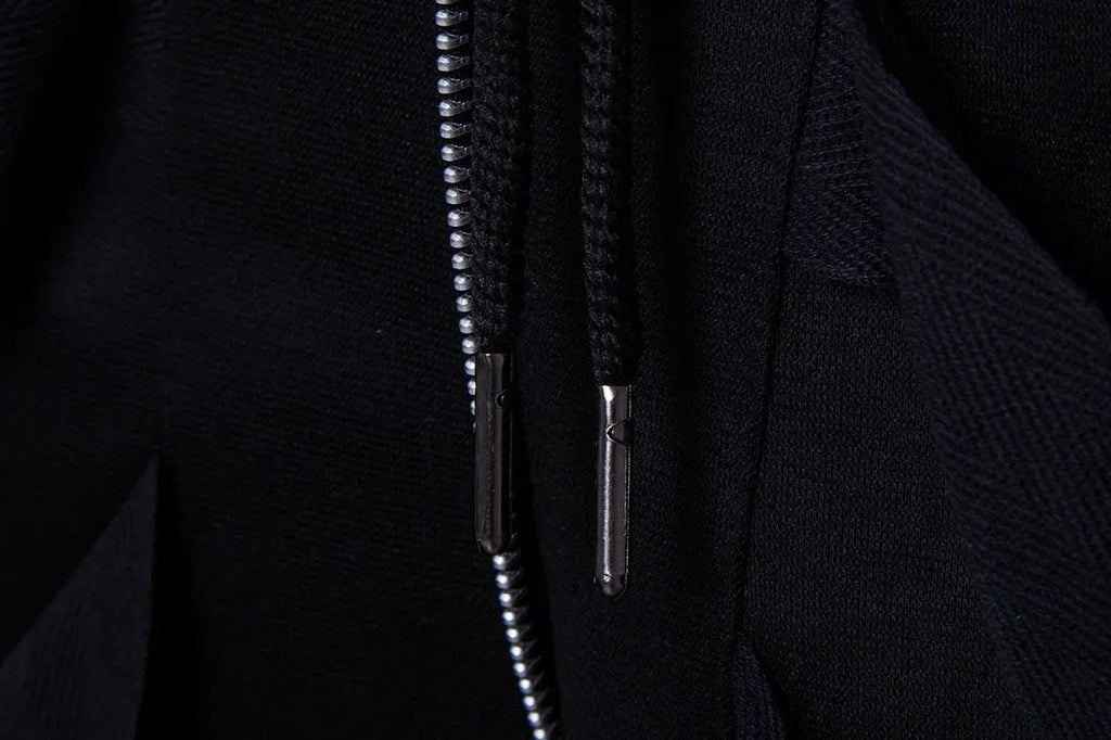 Men's black low crotch cross trousers with tapered cone leg and small hem on a plain background
