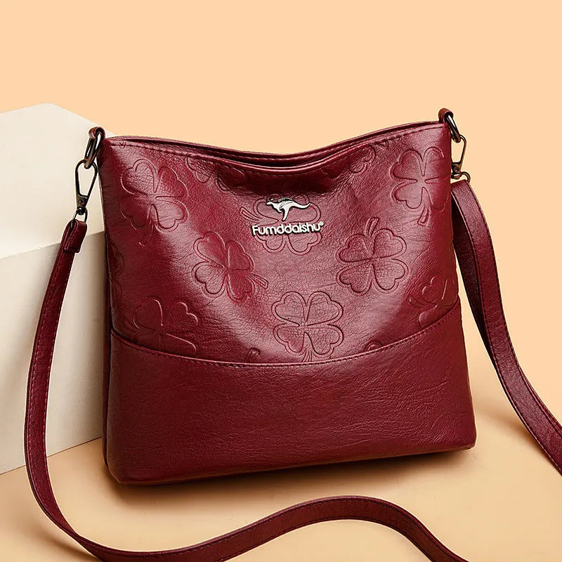 Soft PU leather bucket bag with embossed flower pattern and stitching details in black