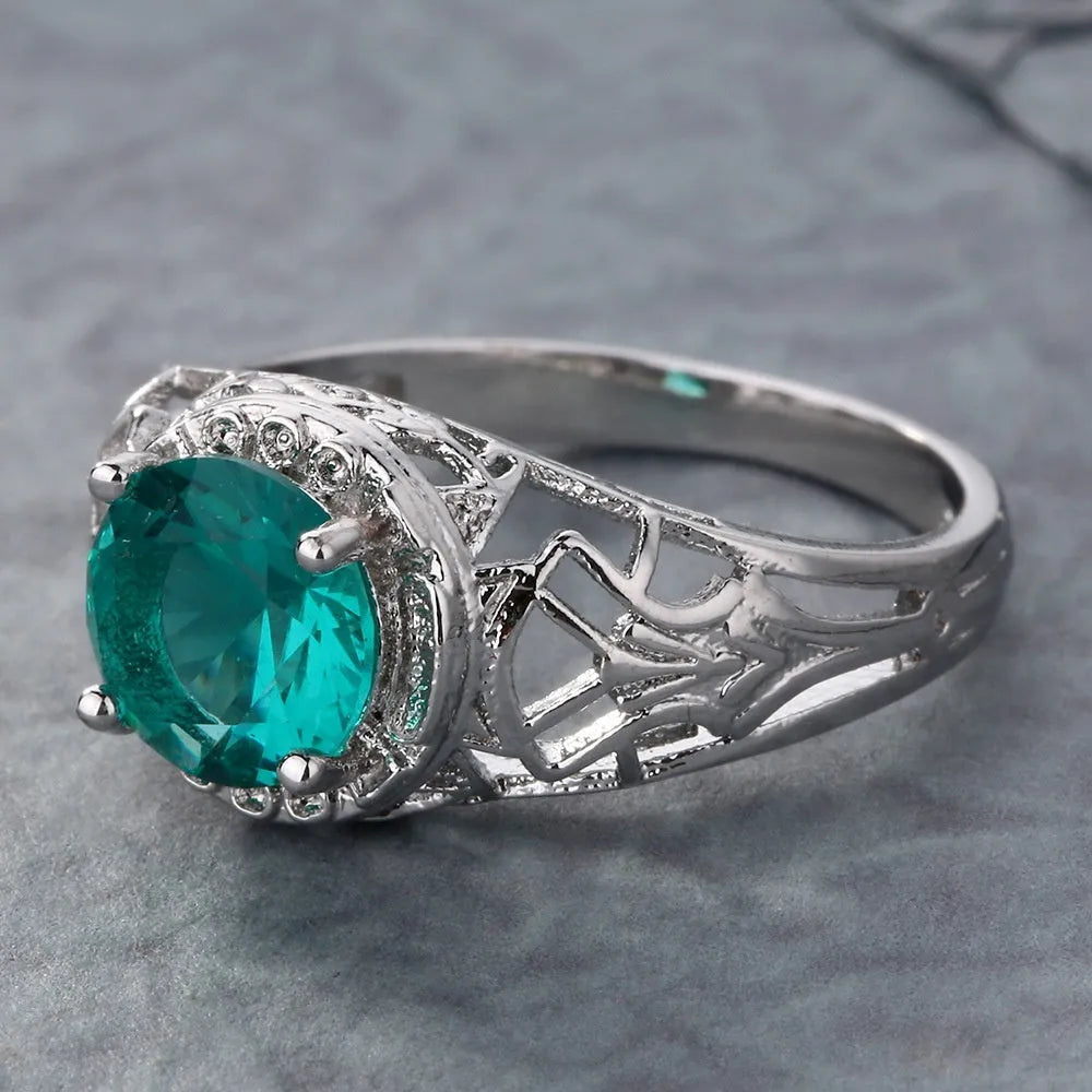 Copper electroplated silver ring with a clear zircon stone inlay on a neutral background