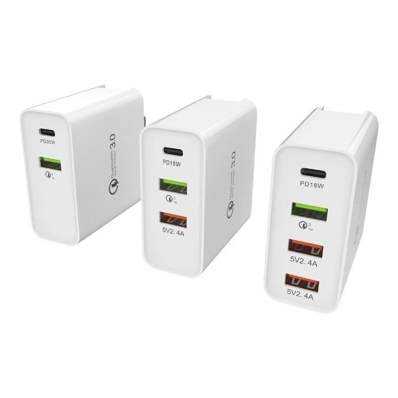 White fast charger with multiple USB ports and a UK plug on a wooden table.
