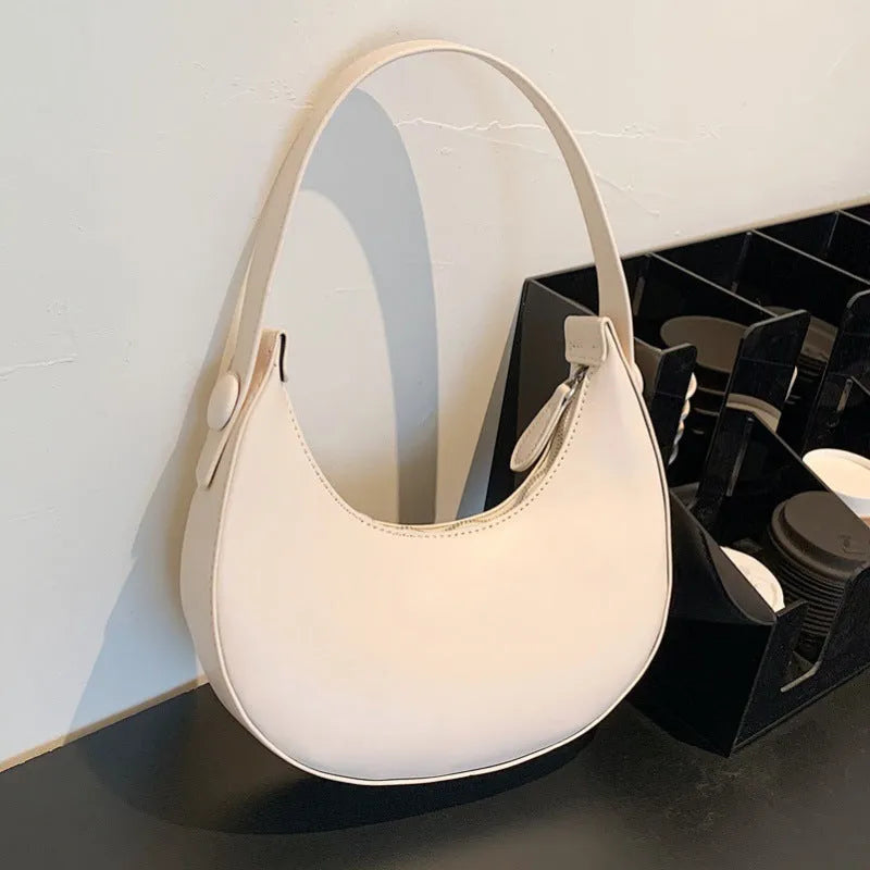 Women's retro-style PU leather shoulder bag in a dumpling shape, shown in black.