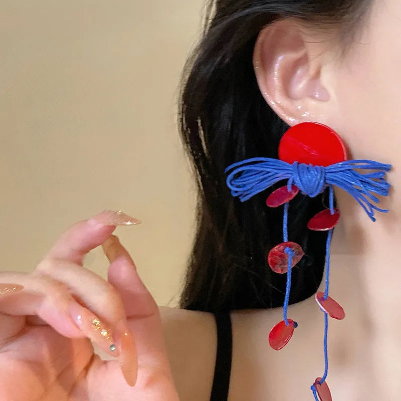 Geometric women's earrings made from blue and silver cloth with round design elements.