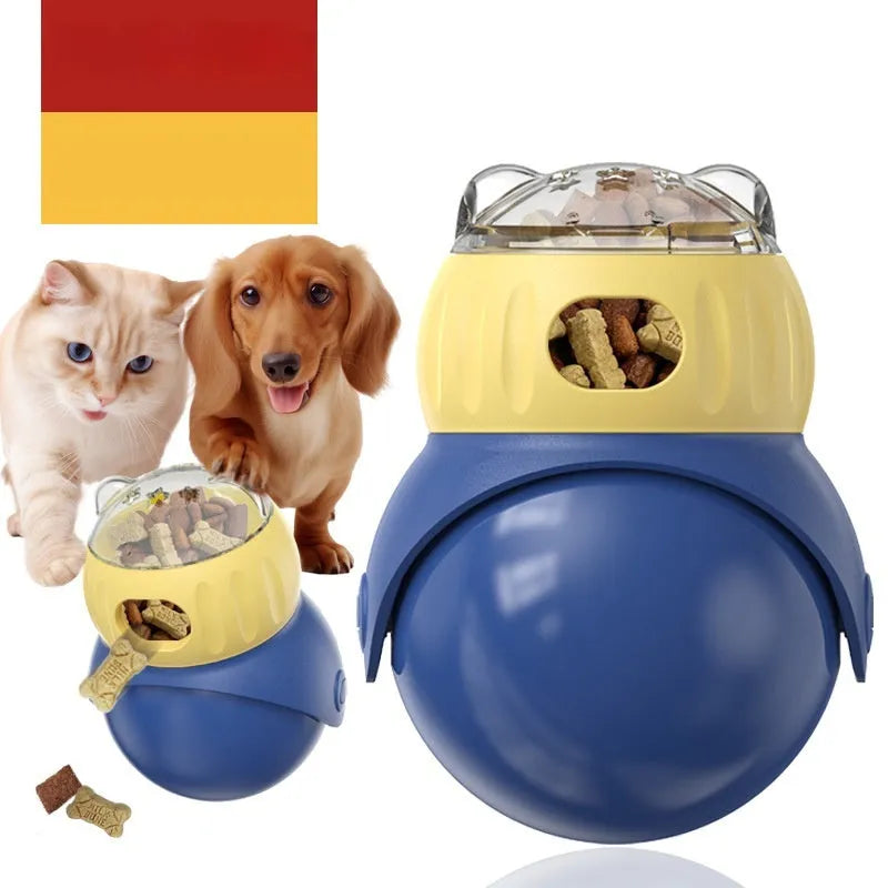 Yellow and blue plastic tumbler owl cat puzzle feeder toy on a wooden floor.