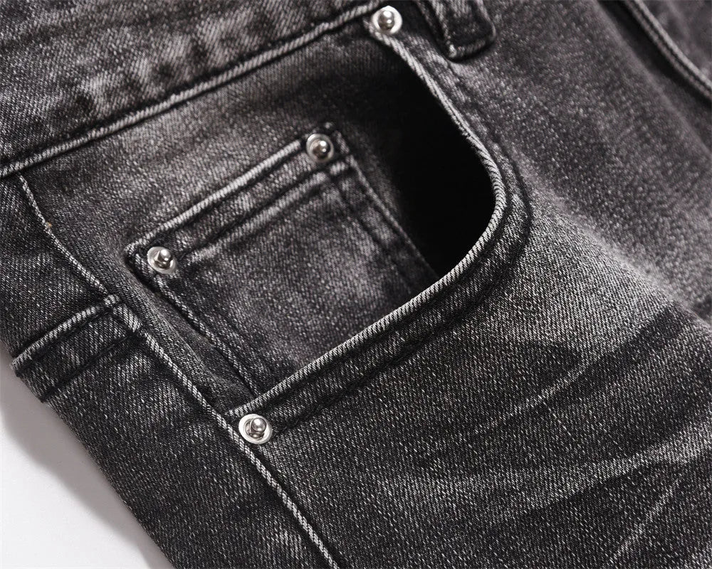 Men's black washed denim jeans on a flat surface showing full leg and pocket details