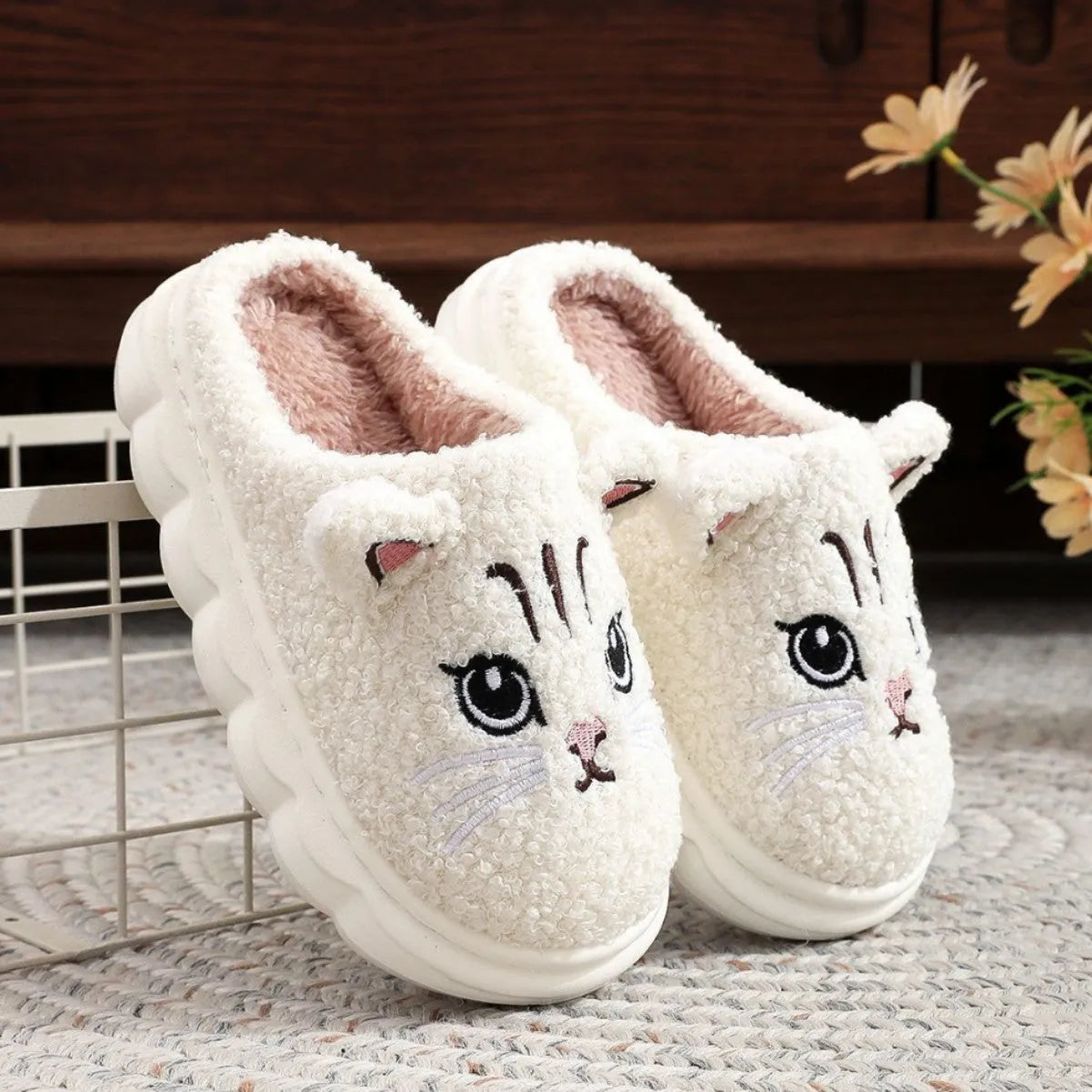 Pair of pink winter cartoon cat fluffy slippers on floor, non-slip EVA sole