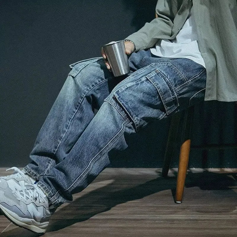 Blue men's loose straight-leg stretch denim trousers on a hanger, showing zip fly placket detail.