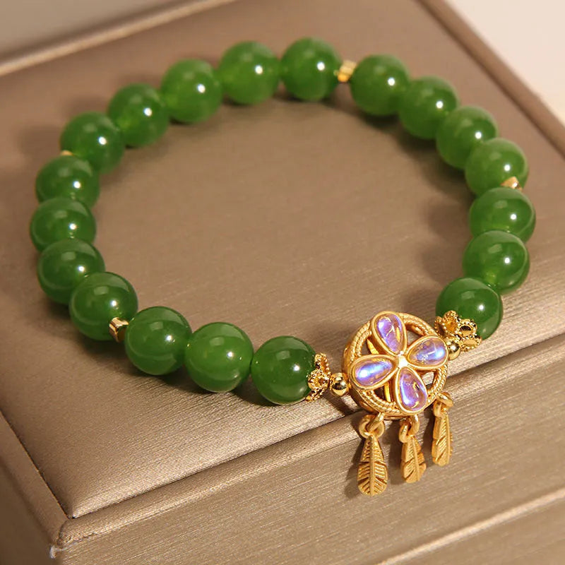 Green jasper crystal four-leaf clover dream catcher pendant on an adjustable women's bracelet.