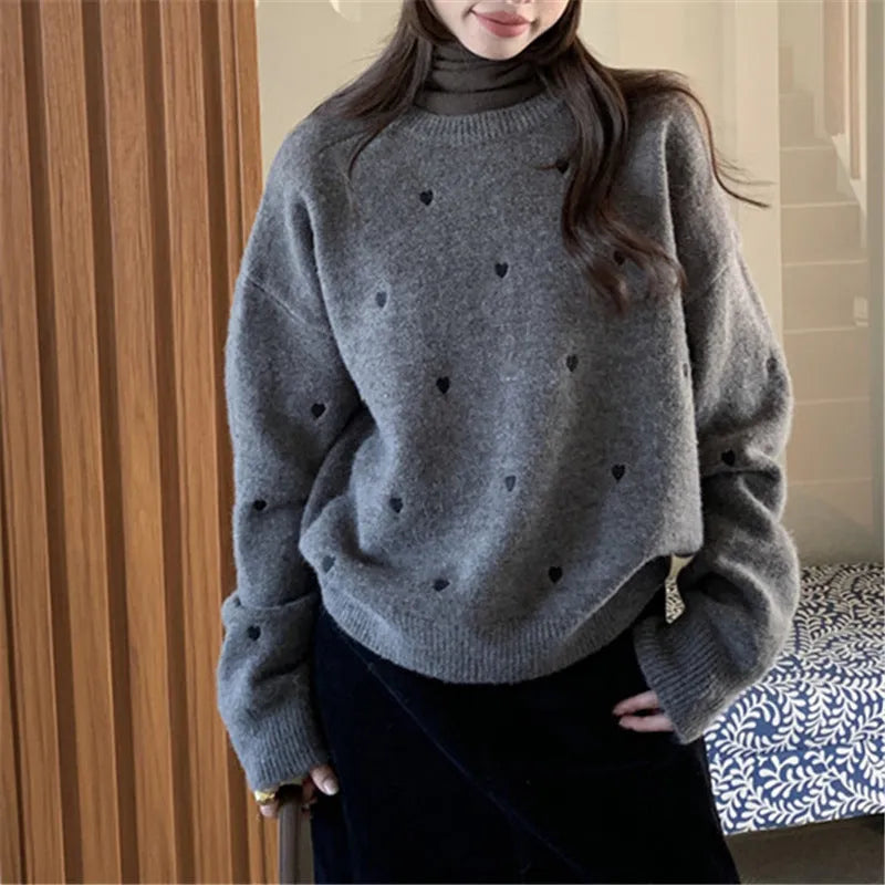 Women's loose beige acrylic pullover sweater with embroidered red love heart design on the chest.