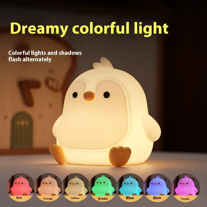 Baby penguin silicone small night lamp in black with warm light mode on bedside table