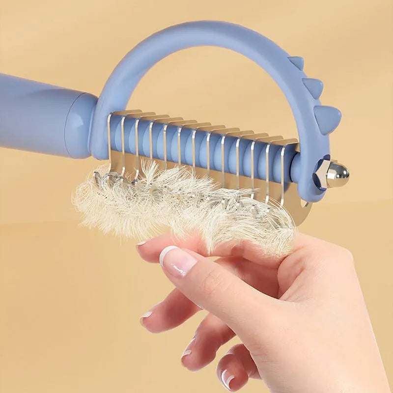 Blue dinosaur-shaped self-cleaning cat grooming brush with double-sided stainless steel pins