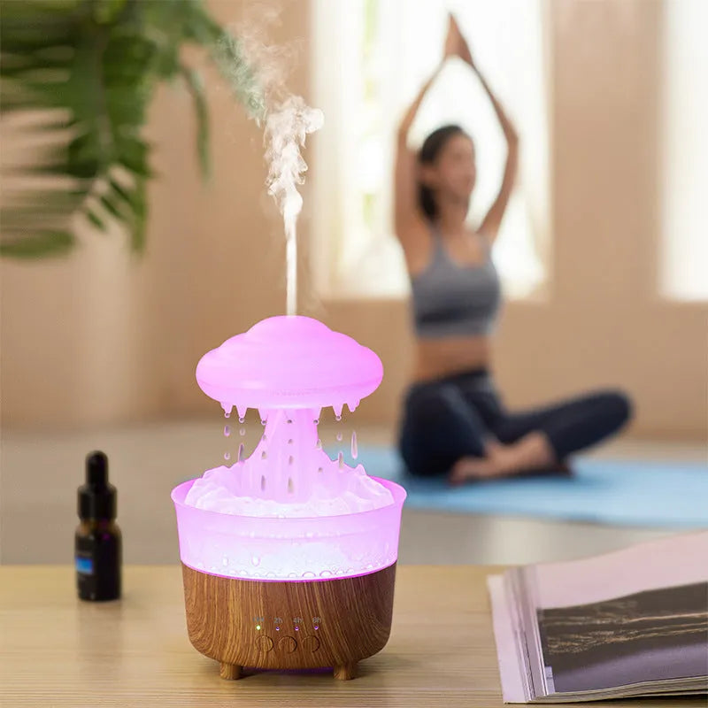 Wood grain white column-shaped rain cloud humidifier diffuser with LED night light on a table.
