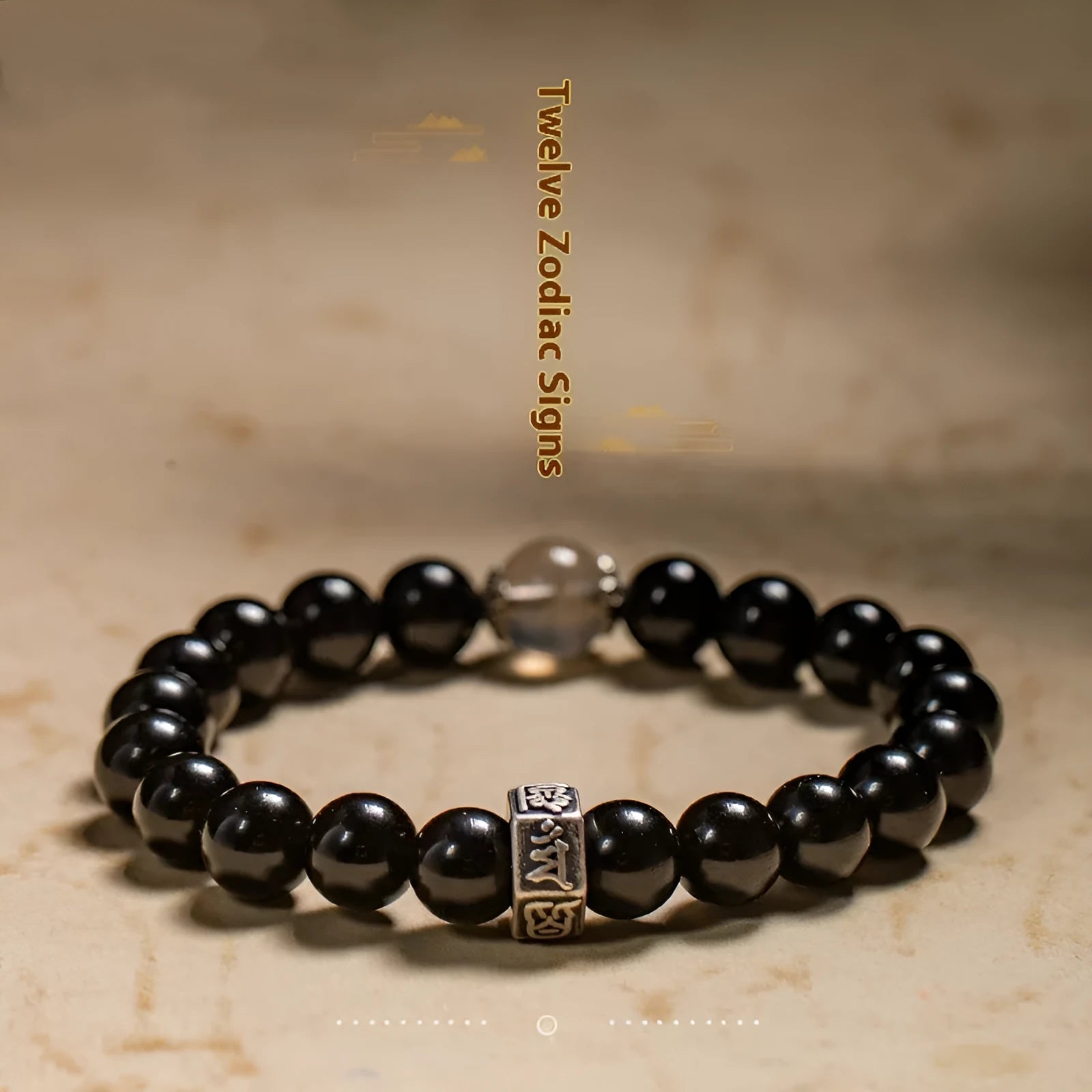 Obsidian bracelet with 8mm beads and a Tibetan zodiac charm on a wrist.