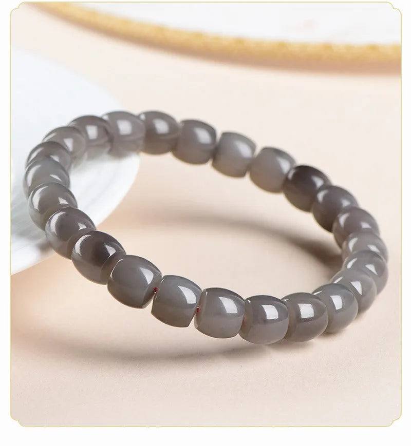 Natural Smokey Violet Hetian jade straight cut bracelet with geometric beads on a wrist.