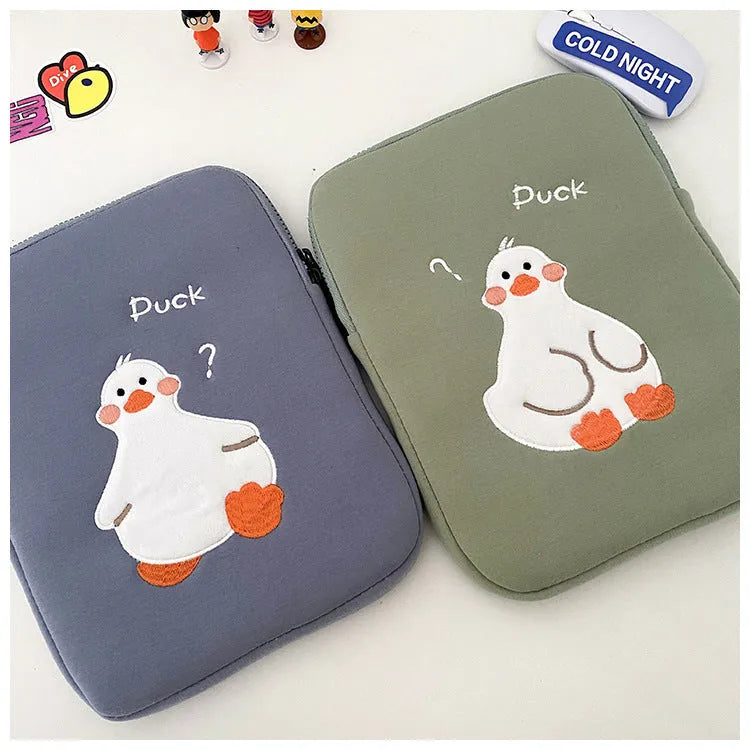 Blue cotton tablet case with an embroidered cartoon duck design and a silver zip closure.