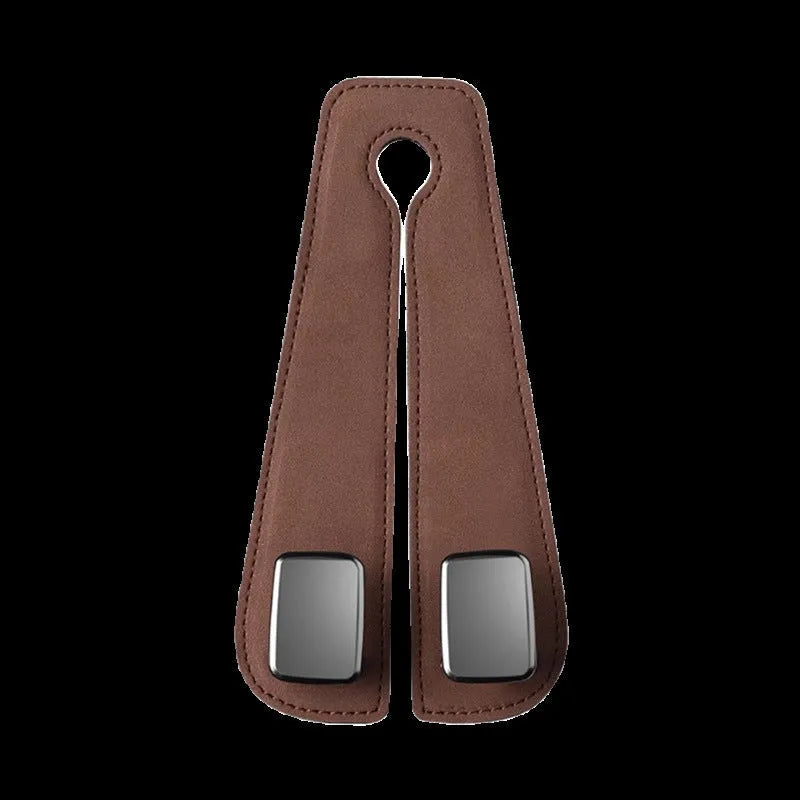 Black car seat hook with suede padding and flip-back design mounted on a grey car seat