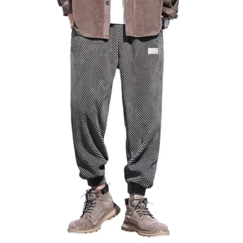 Man wearing grey straight-leg sweatpants with an ankle tie closure.