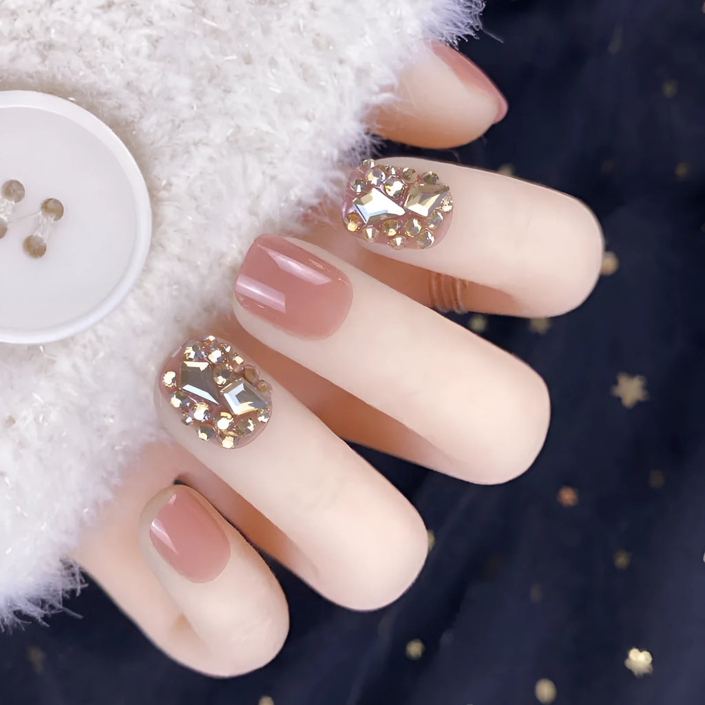 Champagne gold full diamond manicure patches laid out on a surface, showing the sequin finish and adhesive backing
