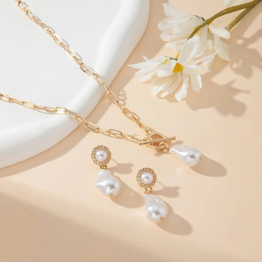 Gold-tone retro baroque necklace and earring set with a pearl pendant on an iron chain.
