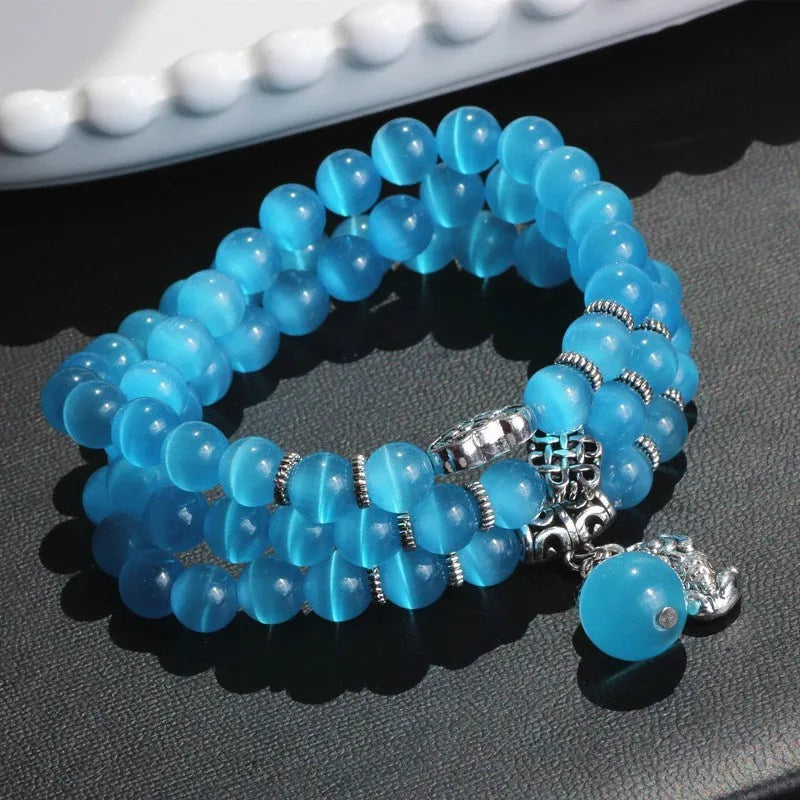 Opal cat eye bracelet with three geometric rings and lucky cat charms on adjustable 52cm cord