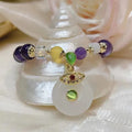 Purple amethyst crystal bracelet with money bag charm and peace buckle on woman's wrist