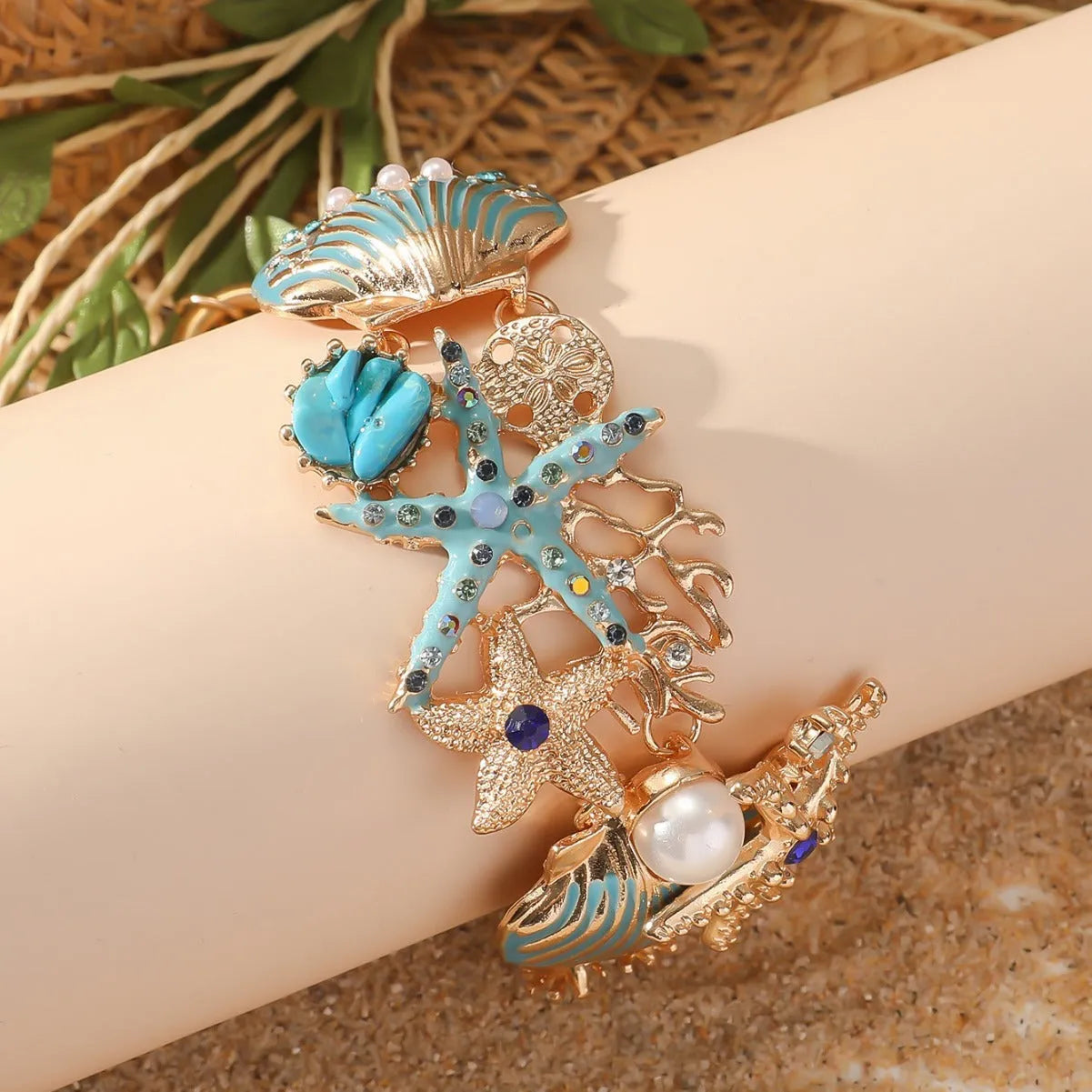 Women's alloy nautical bracelet with boat anchor and starfish charms in coral blue, red, or turquoise.
