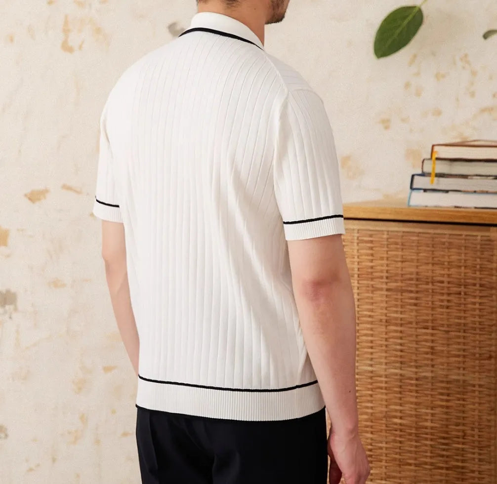 Man's slim fitting short sleeve polo shirt with a lapel collar in black, made from a lightweight knitted fabric.