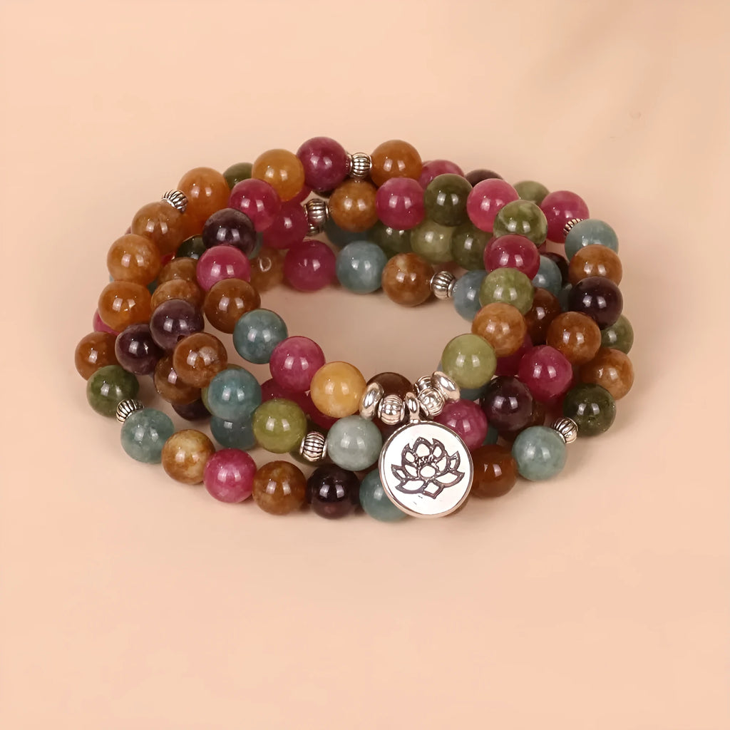 Multi-layer bracelet with 108 dark green tourmaline beads on a silver-toned alloy chain in a lotus design.