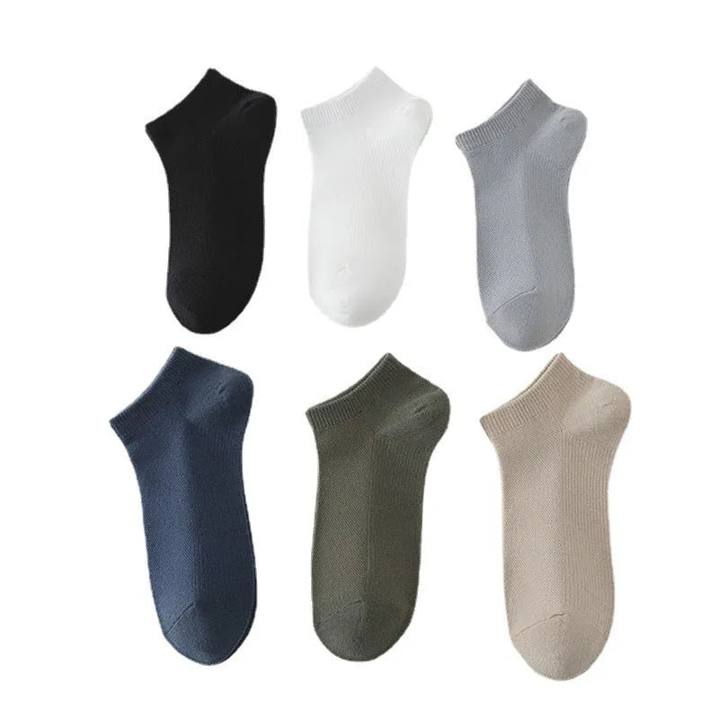 A pair of solid-colour, low-cut boat socks for men made from breathable polyester, shown in one of the six available shade options.