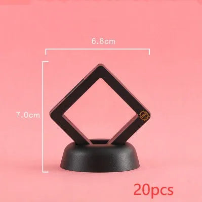 3D floating display case holding a coin suspended between transparent membrane sheets, black frame