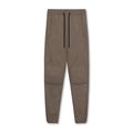 Men's loose grey ankle-tied fitness trousers on a plain background