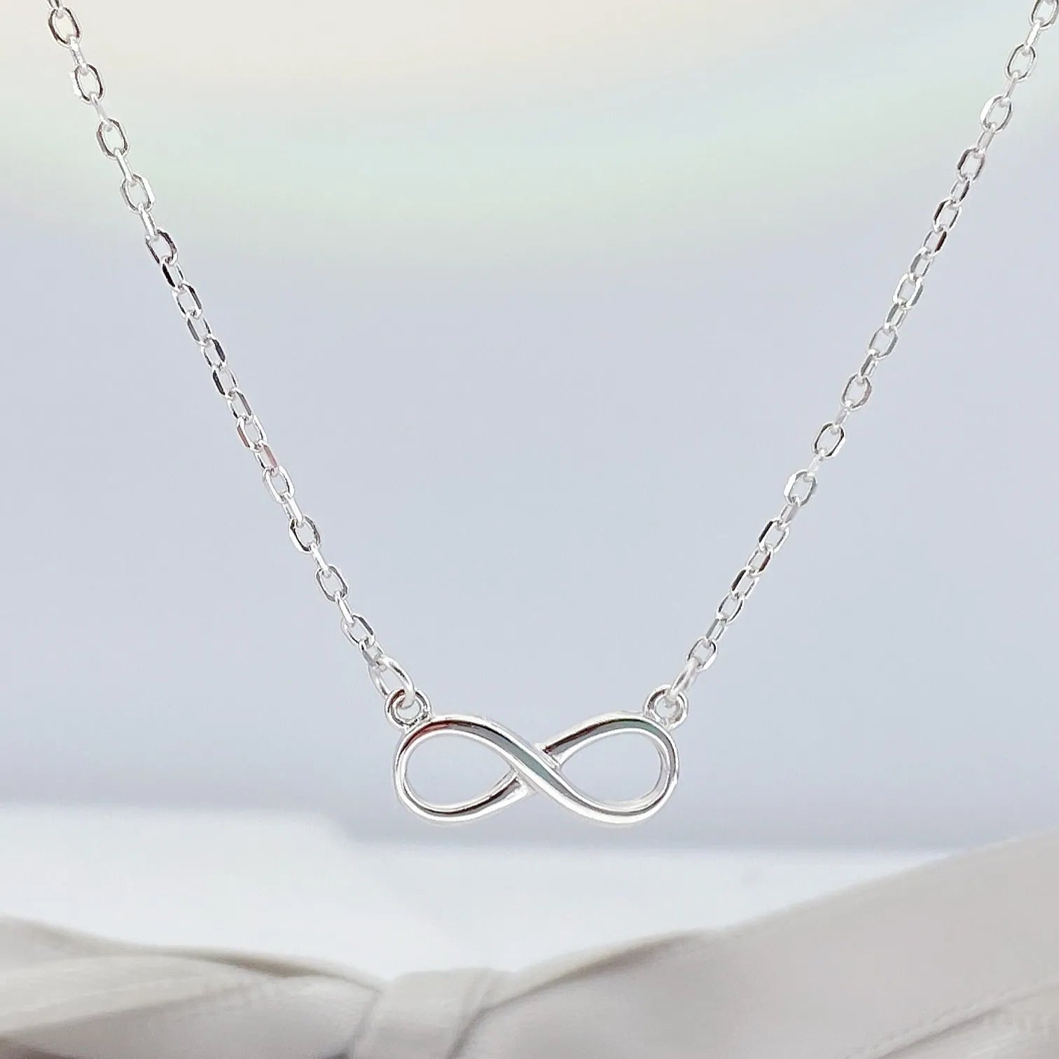 925 silver through-the-body pendant necklace with adjustable chain in platinum finish on collarbone