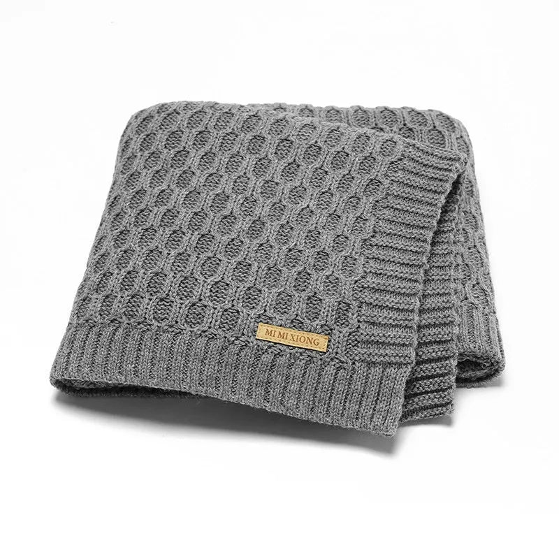 Solid colour baby blanket with textured three-dimensional lines, shown in beige khaki.