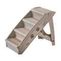 Foldable plastic pet stairs with non-slip mats in beige colour next to a sofa.