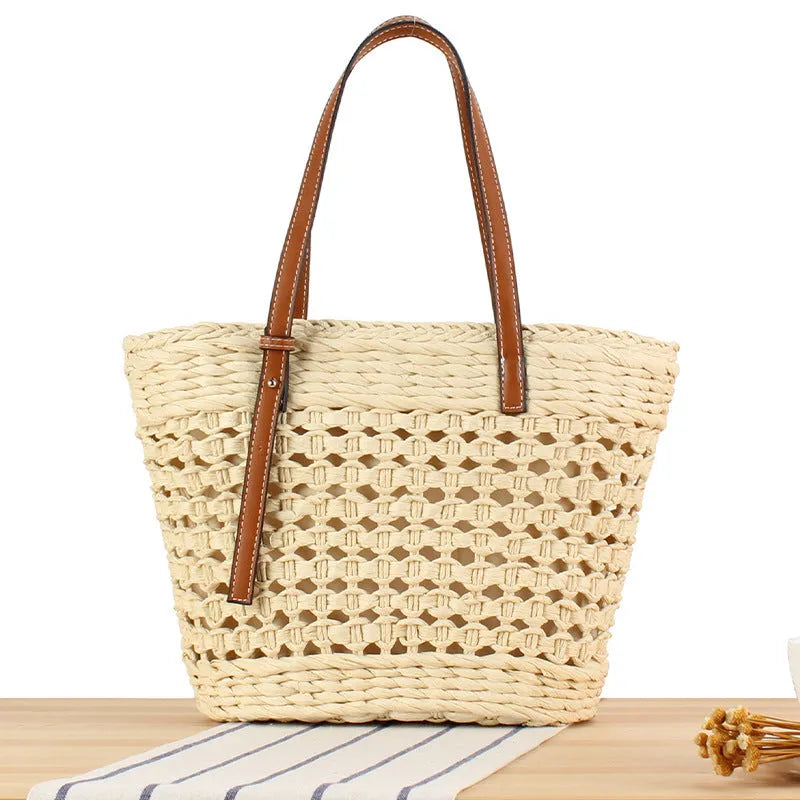 Paper woven shoulder bag with adjustable strap in beige colour showing horizontal square shape and straw decorative elements