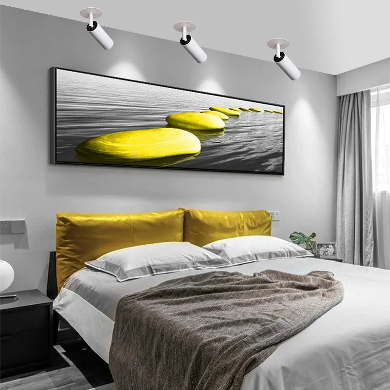 Black recessed cylinder LED spotlight installed in a ceiling track, showing adjustable head.