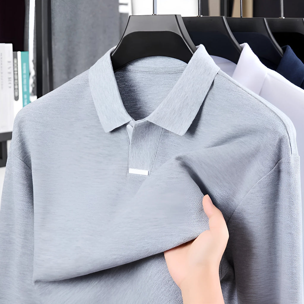 Men's loose fit cotton polo shirt in grey with lapel collar and long sleeves on a mannequin.