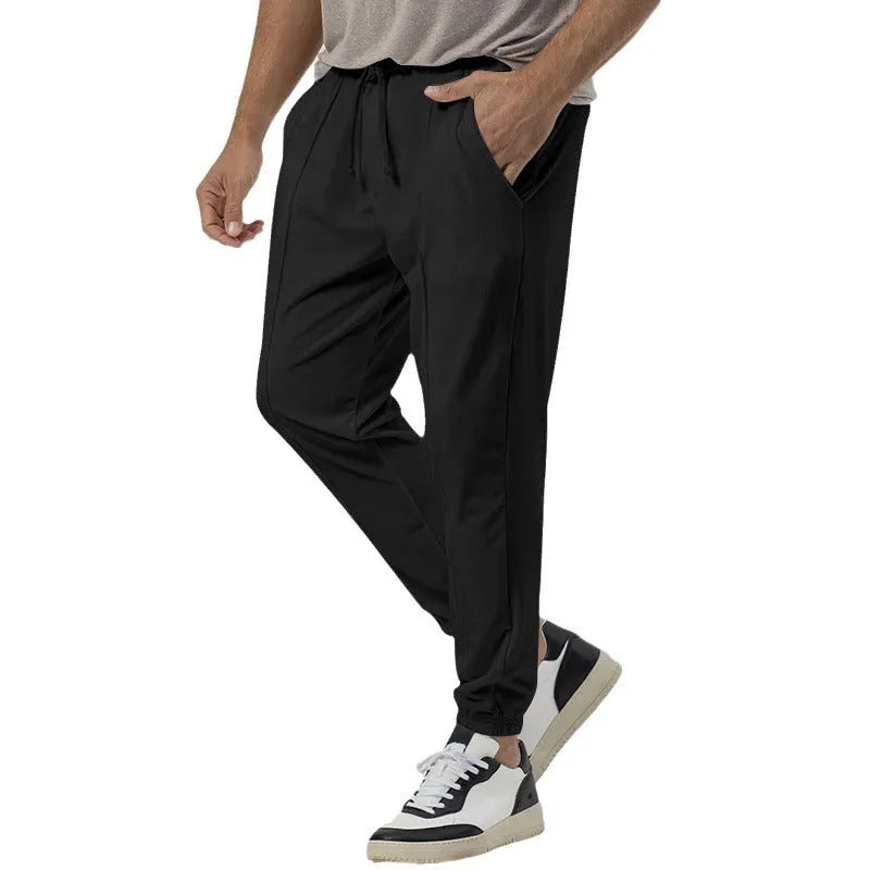 Men's grey straight-leg track sweatpants with a mid-waist, showcasing a relaxed fit and casual style.