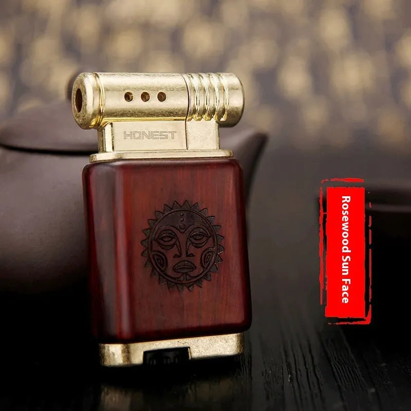 Decorative rosewood and blackwood gas lighter with sun face engraving on metal body.