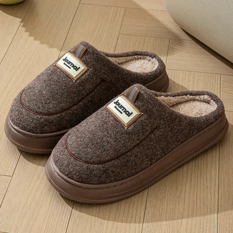 Men's brown and grey suede slippers with a thick sole on a plain background