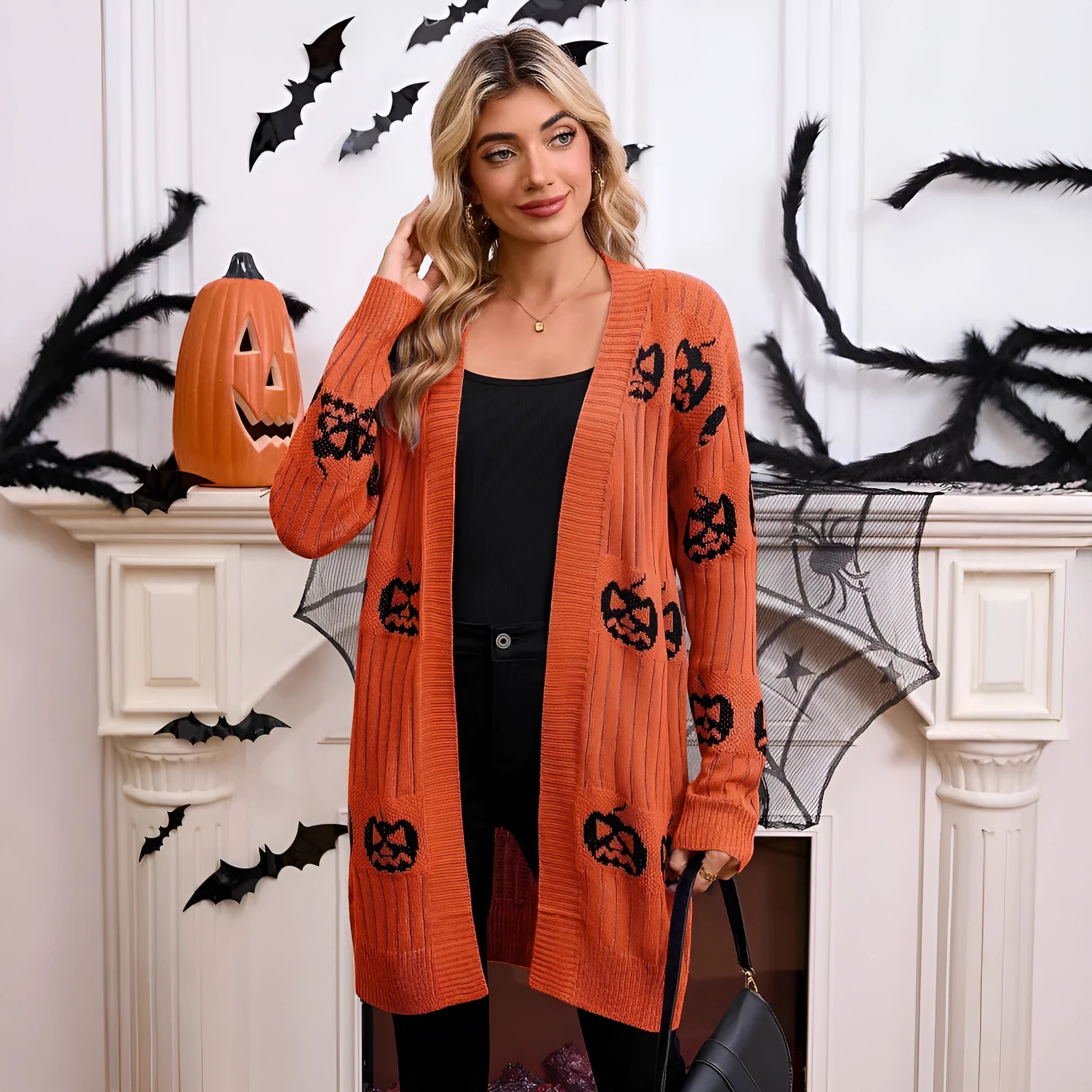 Women's black cardigan with orange knitted pumpkin head jacquard pattern.