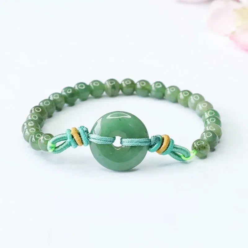 Emerald green jade bracelet with safety buckle closure and star charm on wrist