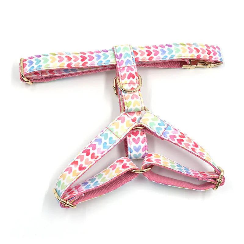 Pink colourful dog chest and back harness with gold buckle and heart-shaped stone details.