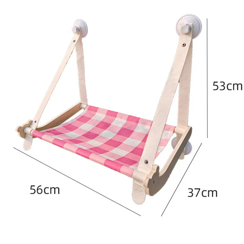 Green wooden cat window hammock with suction cups attached to glass, showing a removable linen mat.