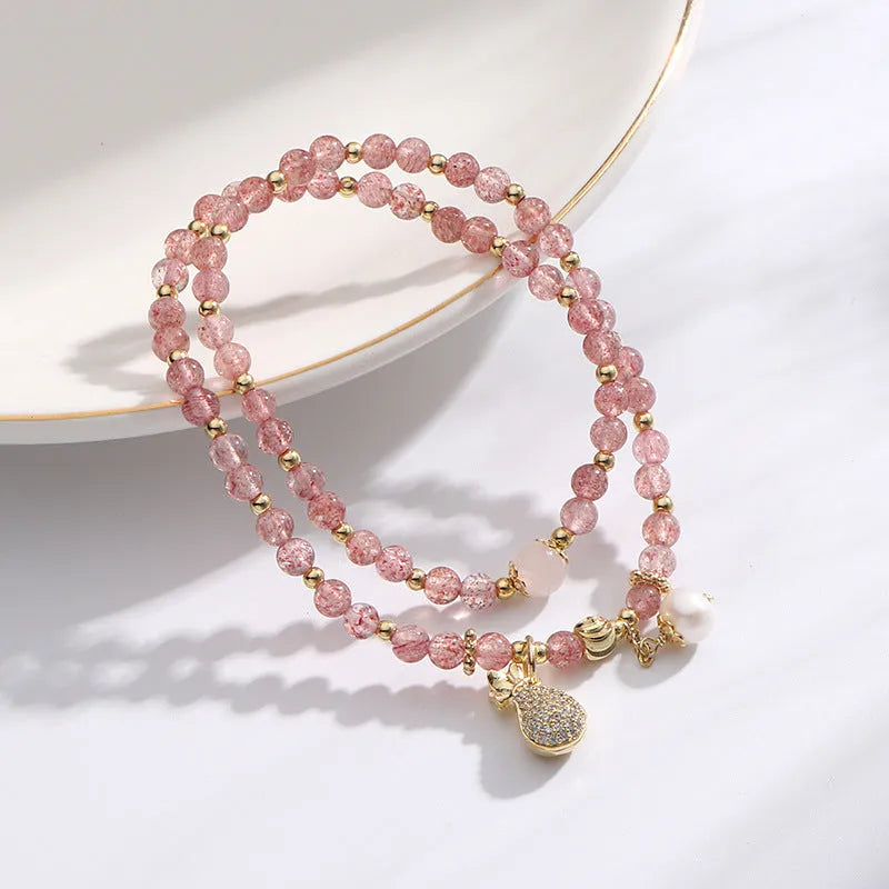 A geometric wallet bracelet for women made from pink strawberry quartz crystal.