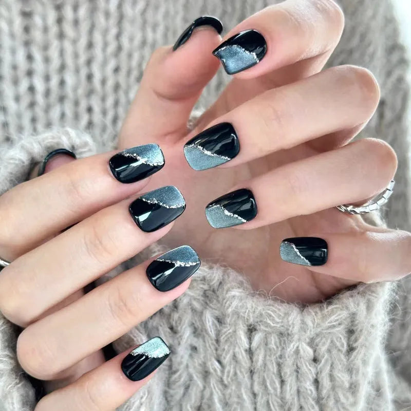 Assortment of sweet girl style false nails in various colours and designs, laid out on a table.
