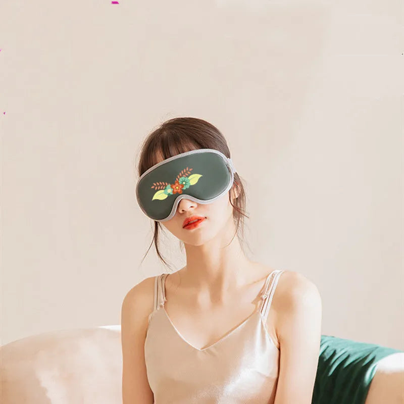 Pink and green suede portable eye spa mask with USB charging for steam heat and vibration massage.
