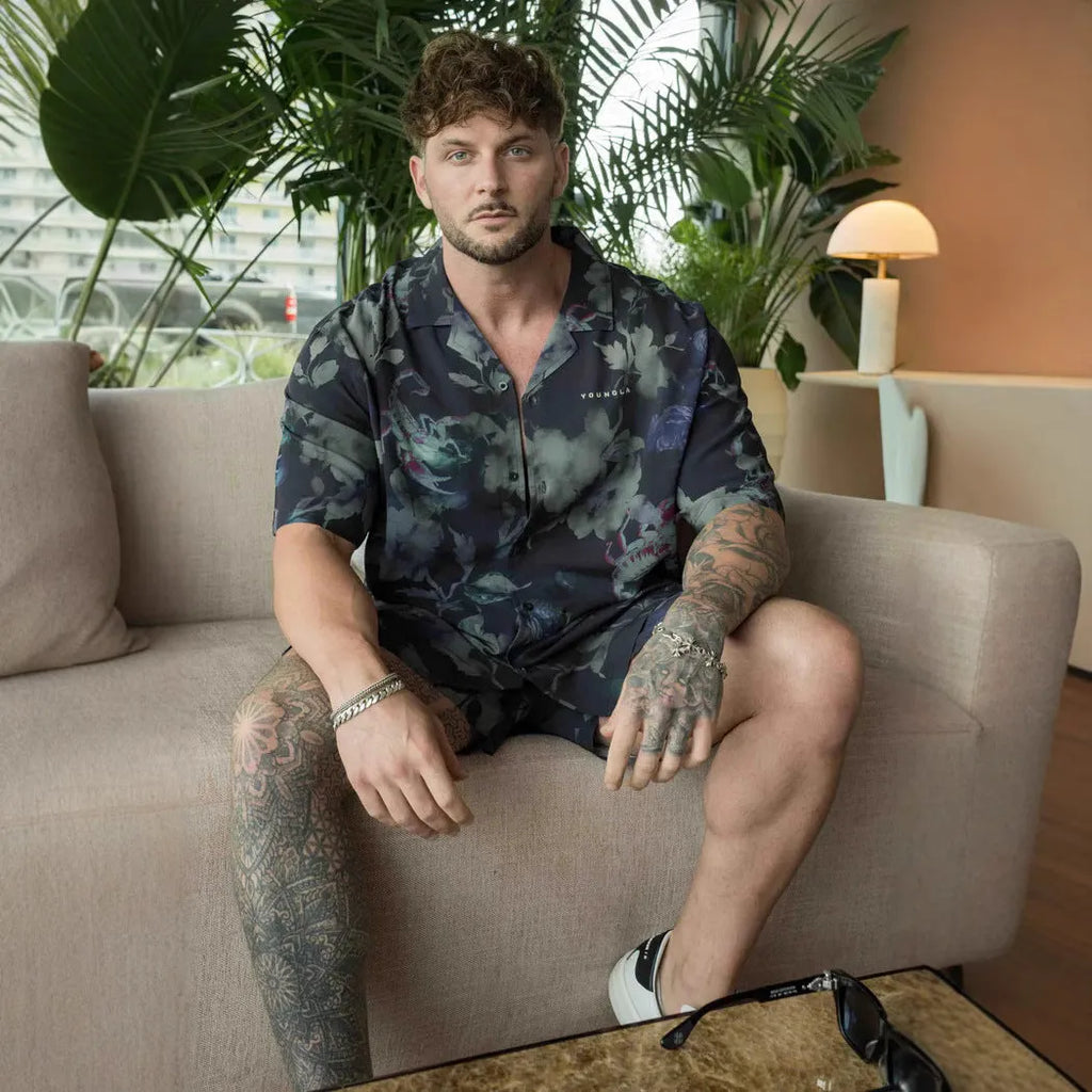 Man wearing a loose, short-sleeved printed floral top in a light colour.