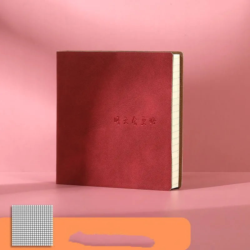Square faux leather notebook open on a table, showing Daolin paper and French fold binding.