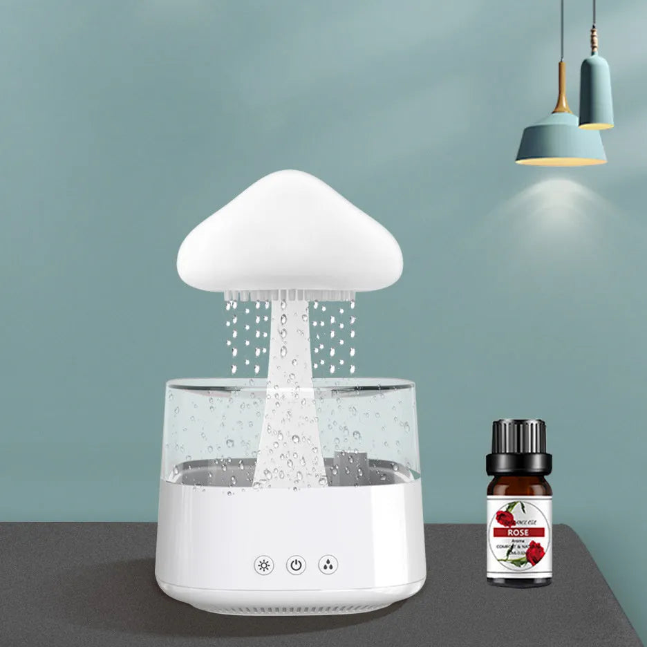 White rain cloud design desk humidifier and aromatherapy diffuser with mushroom-shaped night light on a wooden table.