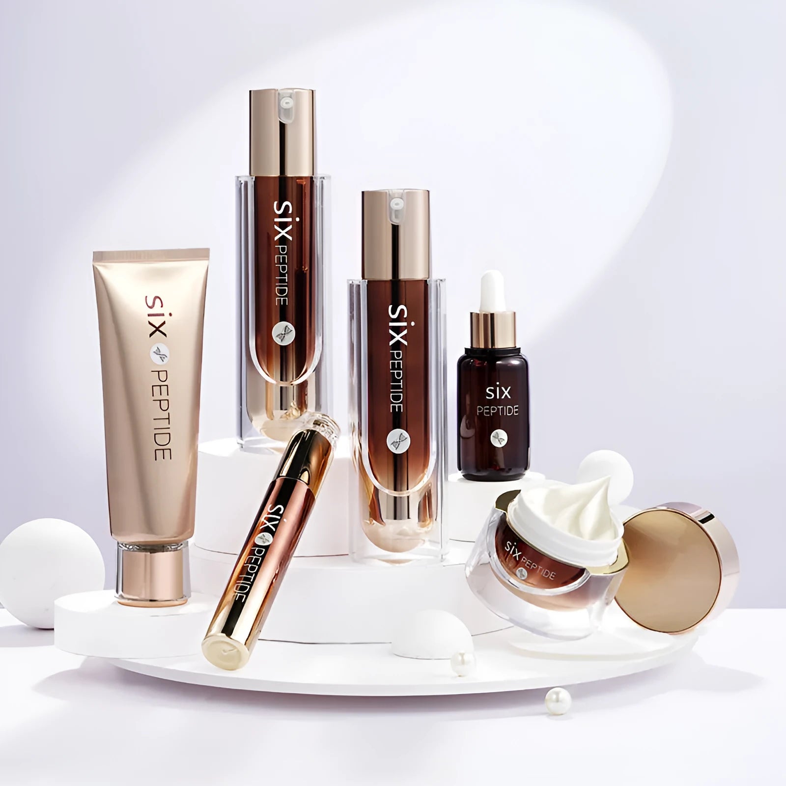 Hexapeptide skin care set of seven bottles and jars including toner, cleanser, cream, essence, eye cream, and BB cream on white background